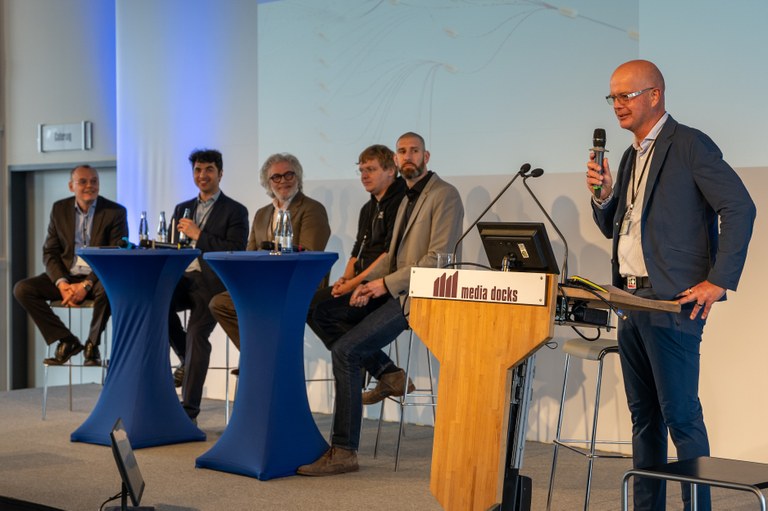 Sechs Männer sitzen auf einer Bühne und Diskutierten die Chancen und Herausforderungen von Anonymisierungstechnologien (v.l.): Engelbert Beyer (Bundesministerium für Bildung und Forschung), Prof. Esfandiar Mohammadi (Universität zu Lübeck), Matthias Steffen (FUSE-AI), Matthias Marx (Chaos Computer Club), Christian Zimmermann (Bosch Mobility) und Tim Suthau (Moderator).