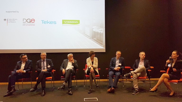 Teilnehmerinnen und Teilnehmer der Podiumsdiskussion sitzen nebeneinander