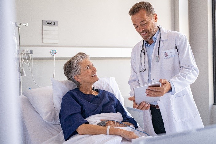 Arzt am Bett einer Patientin im Krankenhaus