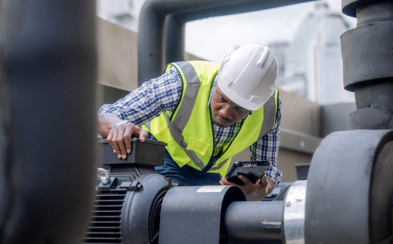 Ein Ingenieur inspiziert eine große industrielle Kreiselpumpe.